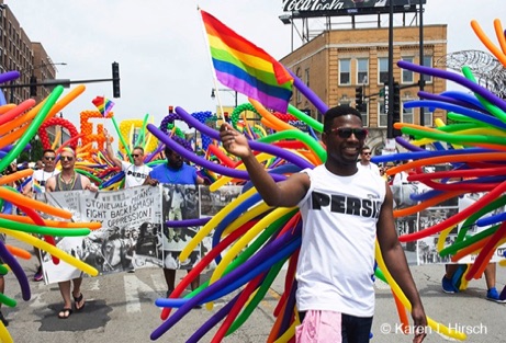 Black man with Persist T shirt wearing colorful balloons on his back